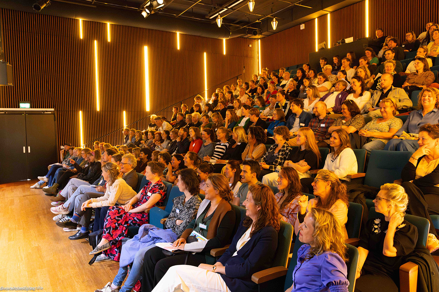 Het publiek luistert naar de keynote van Karim Amghar